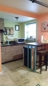 a kitchen with a table in the middle of it at Cozy ground floor rooms at the heart of Jackson Heights in Queens