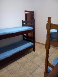 a room with two bunk beds and a mirror at Casa em Praia Grande -SP in Praia Grande