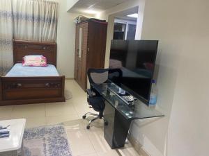 a room with a desk with a television and a bed at Al Yasmeen Tower A in Ajman 