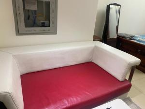 a white couch with a red seat in a room at Al Yasmeen Tower A in Ajman 
