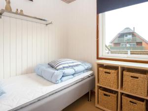 HarboørにあるThree-Bedroom Holiday home in Harboøre 15のベッドと窓が備わる小さな客室です。