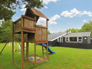 uma casa na árvore com um escorrega e um parque infantil em Holiday home Jerup LX em Jerup