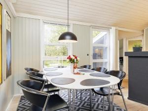 comedor con mesa blanca y sillas negras en Holiday home Jerup LX en Jerup
