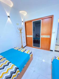 een slaapkamer met een bed en een kast met een spiegel bij فيلا مارينا 4 الساحل الشمالي in El Alamein