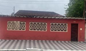 un edificio rojo con dos ventanas y una puerta en Casa em Praia Grande -SP en Praia Grande