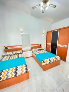 een slaapkamer met 2 bedden en een plafondventilator bij فيلا مارينا 4 الساحل الشمالي in El Alamein