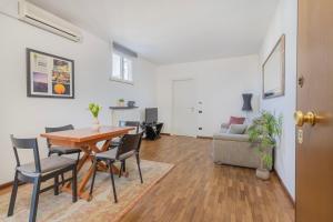 uma sala de estar com uma mesa e cadeiras e um sofá em Simona Apartments em Parma
