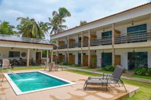 a resort with a swimming pool and a building at Pousada Estação do Mar in Japaratinga