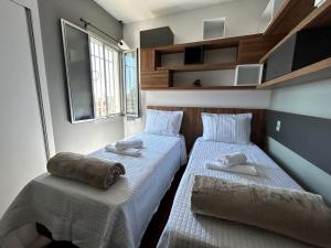 two beds in a small room with towels on them at Apartamento em Belo Horizonte 2 in Belo Horizonte