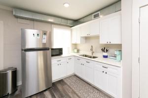 uma cozinha com armários brancos e um frigorífico de aço inoxidável em SunKissed em Bay St. Louis