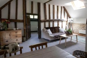 a living room with a couch and a table at Saltmarsh Farmhouse in West Dean