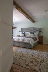 a bedroom with a bed and a rug at Saltmarsh Farmhouse in West Dean