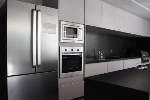 a kitchen with stainless steel appliances and a microwave at Moderno e Aconchegante Studio II in Belo Horizonte