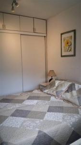 1 dormitorio con 1 cama con manta a cuadros en Apartamento para familia o parejas, en Punta del Este