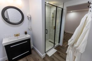 bagno con doccia, lavandino e specchio di Auberge Nouvelle-France a Ville-Marie