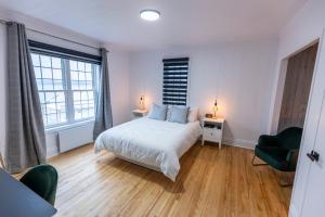 Ville-MarieにあるAuberge Nouvelle-Franceのベッドルーム1室(ベッド1台、椅子2脚、ランプ2つ付)