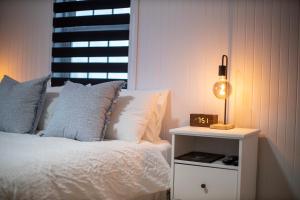 a bedroom with a bed and a nightstand with a lamp at Auberge Nouvelle-France in Ville-Marie