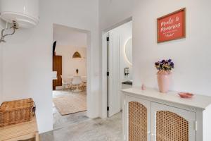 una sala de estar con una mesa con un jarrón de flores en Casa do Largo - Lago do Alqueva en Campinho