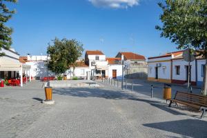 una calle en una ciudad con un banco y edificios en Casa do Largo - Lago do Alqueva en Campinho