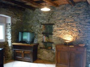 a living room with a tv and a stone wall at Casa Valentini in Quercitello