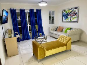sala de estar con cortinas azules y sofá amarillo en Apartamento Amplio en Residencial de 2 Habitaciones, en Mendoza