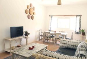 a living room with a couch and a table with a television at Manasha Apartment 1 in Watamu
