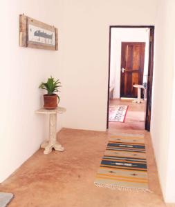 a hallway with a potted plant on a table next to a door at Manasha Apartment 1 in Watamu