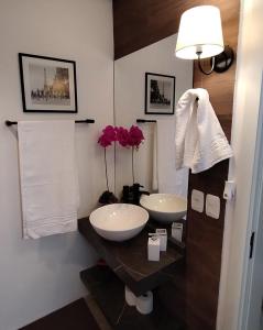 a bathroom with two sinks and a mirror at Suites nas Nuvens Premium in Gramado