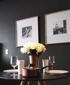 格拉馬杜的住宿－Suites nas Nuvens Premium，一张桌子,上面放着花瓶和两杯眼镜