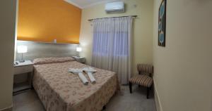 ein Hotelzimmer mit einem Bett mit Handtüchern darauf in der Unterkunft Hotel Gran Habana in Termas de Río Hondo