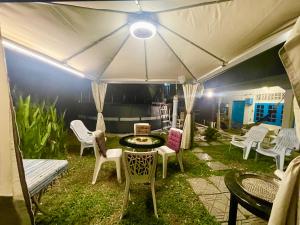 een groep stoelen en een tafel onder een tent bij Dar Yasmine Motel in Pantai Cenang