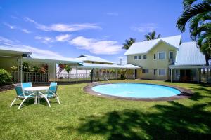 a backyard with a table and chairs and a pool at Grand Melemele home in Pepeekeo