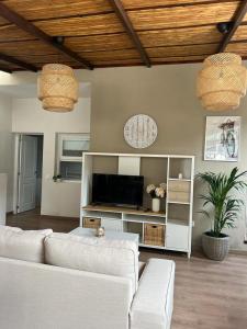 uma sala de estar com um sofá branco e uma televisão em Casa Rural "El Patio de Paca" em Tegueste
