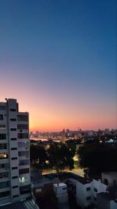 een uitzicht op de stad bij zonsondergang vanuit een gebouw bij Apartamento recién renovado en Punta Carretas in Montevideo