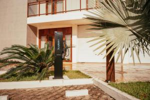 eine Parkuhr vor einem Gebäude mit einer Palme in der Unterkunft Hotel Icaraí Beach in Icaraí + 20 Fotos