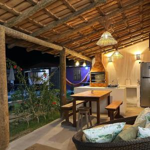 a kitchen and dining area with a table and a kitchen and a kitchen at Casinhas da Serena - Casa cacau in Caraíva