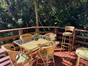 a patio with a table and chairs on a deck at Double Deck - Linda vista com Jacuzzi in Palhoça