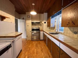 a large kitchen with wooden floors and stainless steel appliances at Character house in North Dunbar in Vancouver