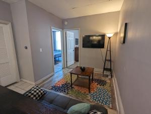 ein Wohnzimmer mit einem Tisch und einem TV an der Wand in der Unterkunft Charming Apartments in the Heart of Robinson in Robinson