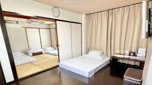 Habitación con 2 camas y espejo. en Reynaville 4F / Vacation STAY 2134, en Tokushima