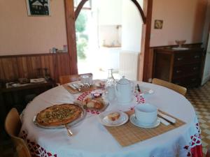 una mesa con un plato de comida y una pizza en ella en Guestroom Renazé, 1 pièce, 2 personnes - FR-1-600-229, en Congrier