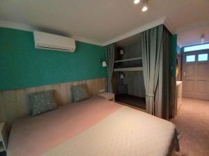 a bedroom with a white bed and a green wall at Studio in Balatonlelle 45323 in Balatonlelle