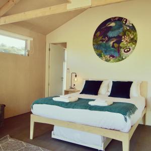 um quarto com uma cama grande e um cobertor verde em One O One Cabins, Waiheke Island em Oneroa
