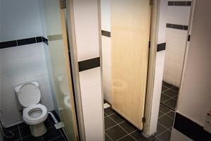 een badkamer met een toilet in een stal bij Upspot Kuching Waterfront Premium Hostel in Kuching