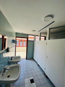 a bathroom with three sinks and stalls in it at HOSTAL 469 in La Serena