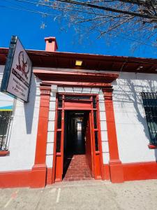 an orange and white building with a red door at HOSTAL 469 in La Serena