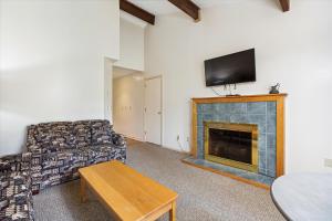 a living room with a couch and a fireplace at Cedarbrook Queen Suite 203 in Killington