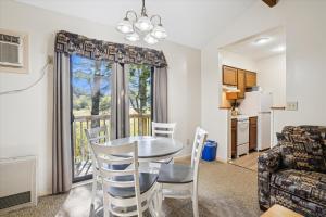 ein Wohnzimmer mit einem Tisch und Stühlen sowie eine Küche in der Unterkunft Cedarbrook Queen Suite 203 in Killington