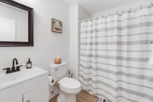 a bathroom with a white toilet and a shower curtain at Beautiful 6 bed 3 bath home in quiet neighborhood in Wichita