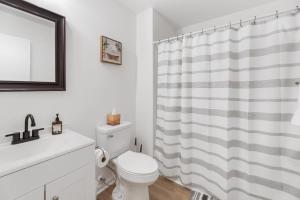a bathroom with a white toilet and a shower curtain at Beautiful 6 bed 3 bath home in quiet neighborhood in Wichita +28 photos